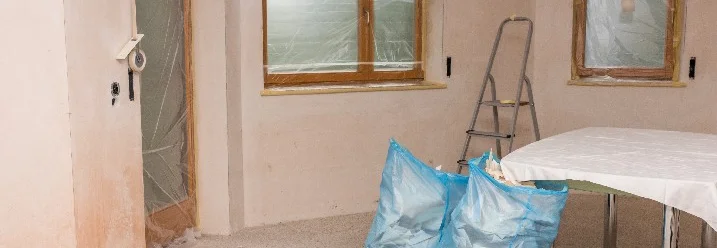 Renovierter Raum mit Müllsäcken und abgeklebten Fenstern